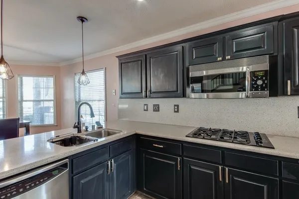 a kitchen with stainless steel appliances a stove and a microwave