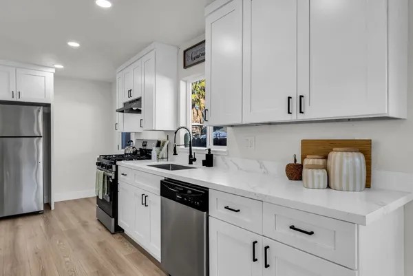 a large kitchen with kitchen island a sink table and chairs