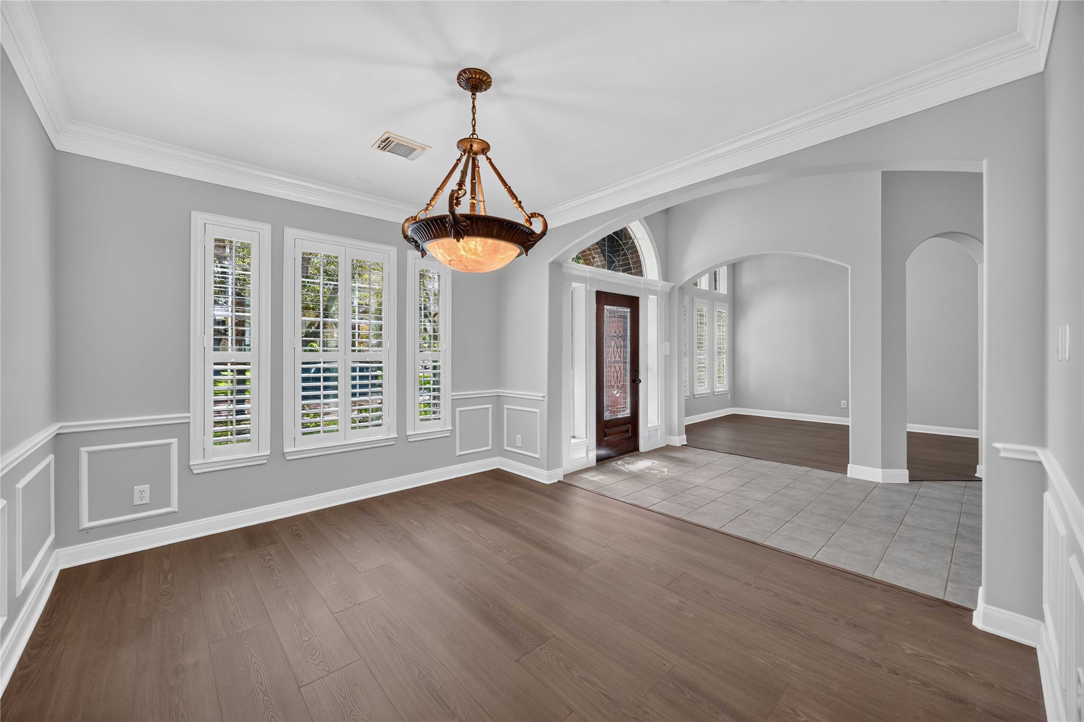 3303 Raleigh Row Missouri City, TX 77459 - Photo 9 of 50 Elegant entryway and Formals featuring rich Laminate wood floors, classic wainscoting, and abundant natural light through large windows with plantation shutters.