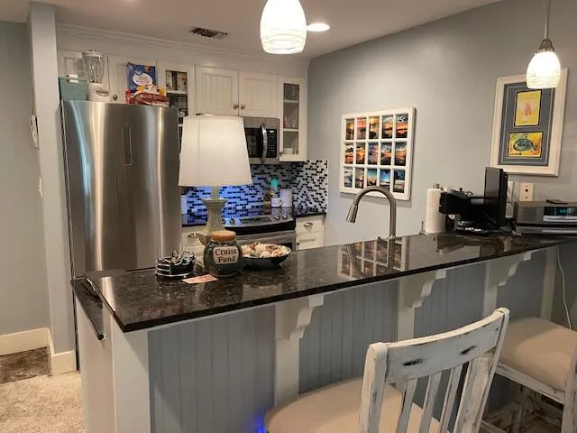 a kitchen with stainless steel appliances granite countertop a sink refrigerator and microwave