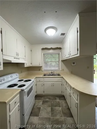 a kitchen with a sink stove and cabinets
