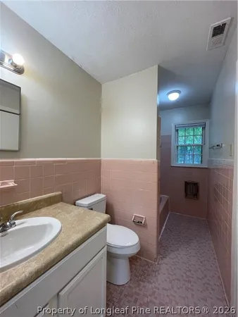 a bathroom with a granite countertop toilet a sink and a mirror