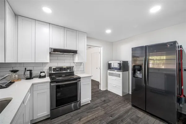 a view of a kitchen with refrigerator and windows