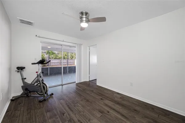 a view of a livingroom with wooden floor and a ceiling fan