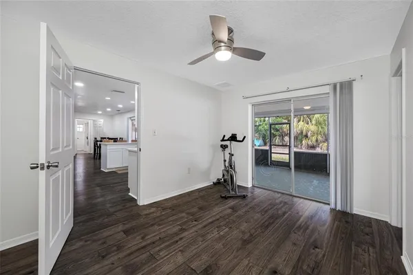 a view of empty room with wooden floor and ceiling fan
