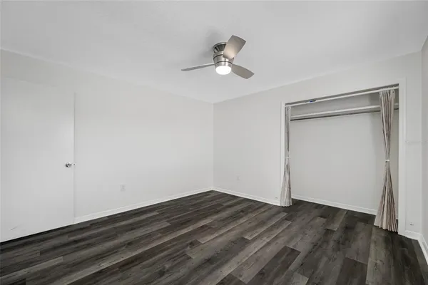 a view of room with wooden floor and ceiling fan