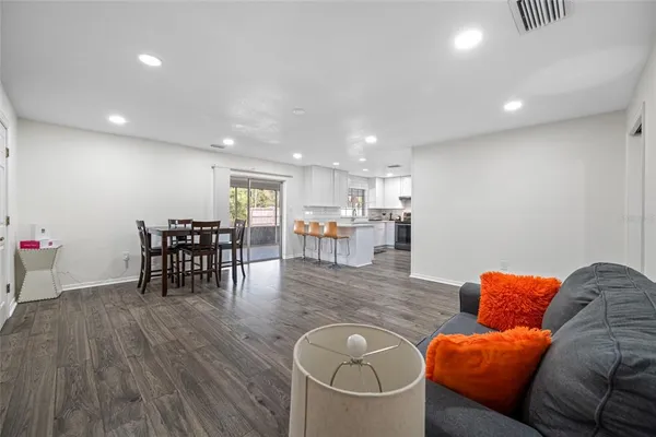 a living room with stainless steel appliances a table and chairs