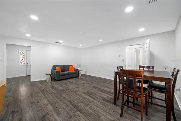 a kitchen with stainless steel appliances granite countertop a refrigerator a sink a stove a dining table and chairs