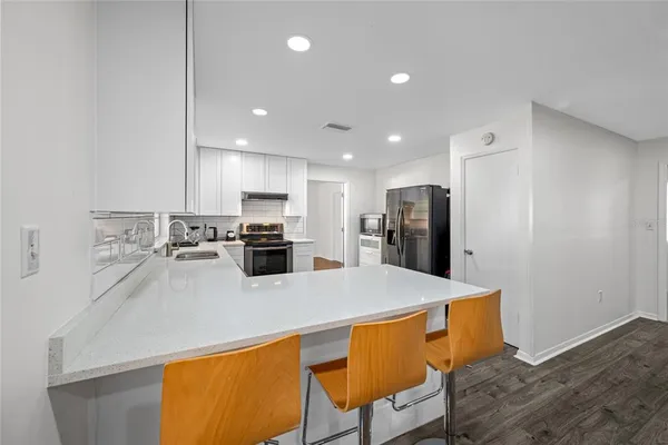 a kitchen with a stove a sink and a refrigerator