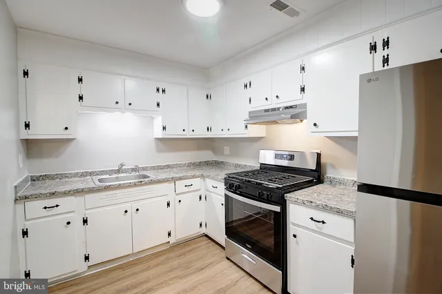 a kitchen with granite countertop white cabinets and white appliances