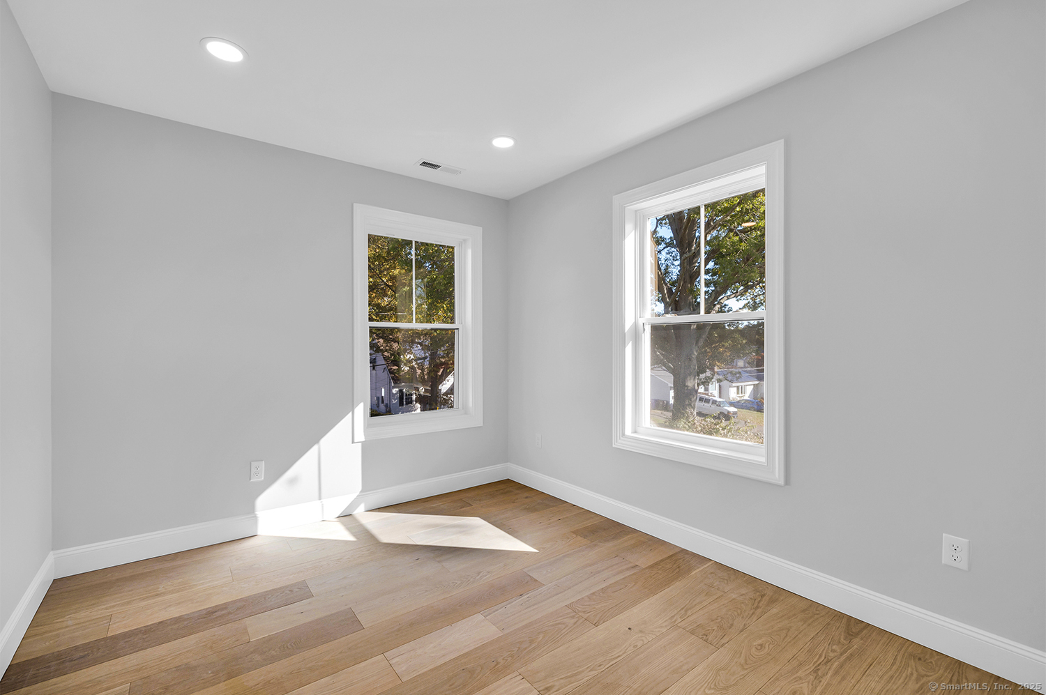 183 Vesper Street Fairfield, CT 06825 - Photo 15 of 21 an empty room with wooden floor and windows