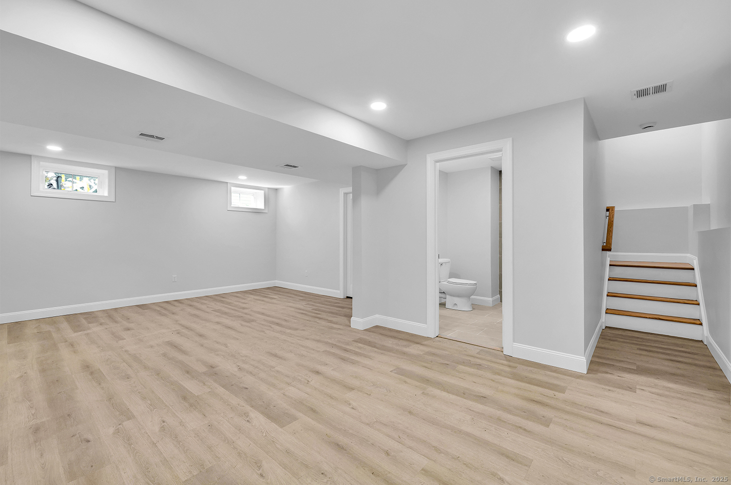 183 Vesper Street Fairfield, CT 06825 - Photo 19 of 21 a view of an empty room with wooden floor and stairs