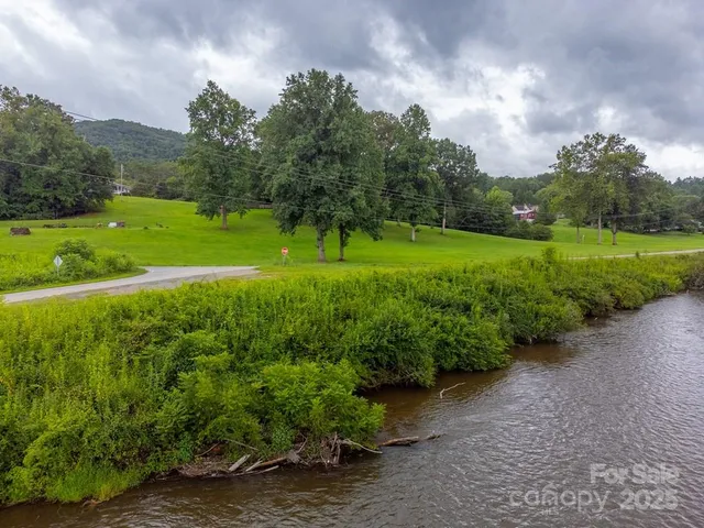 a view of a street with a yard and many trees