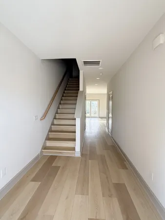 a view of entryway and hall with wooden floor