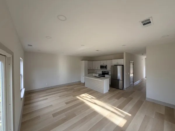 a view of a kitchen with a sink and a refrigerator