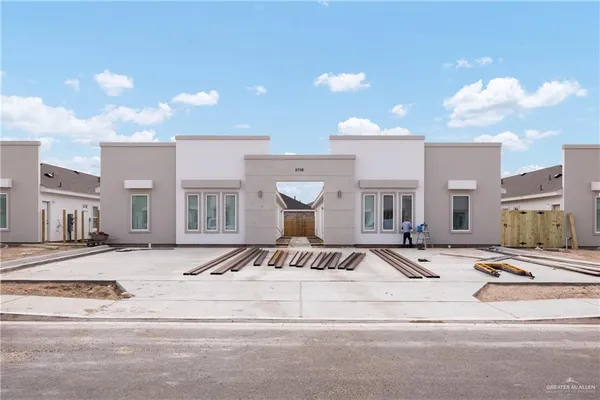a front view of a building with cars parked