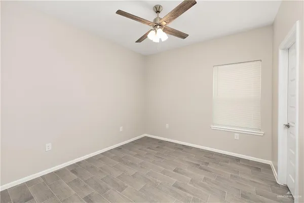 an empty room with a window and a fan