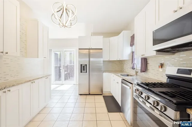 a kitchen with stainless steel appliances granite countertop a stove a sink and a refrigerator