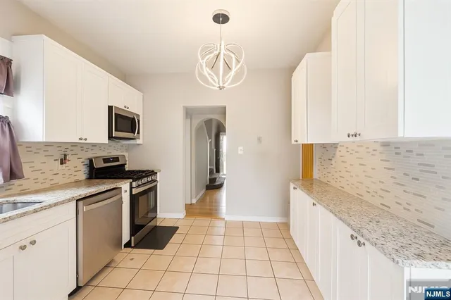 a kitchen with stainless steel appliances granite countertop a sink and a stove