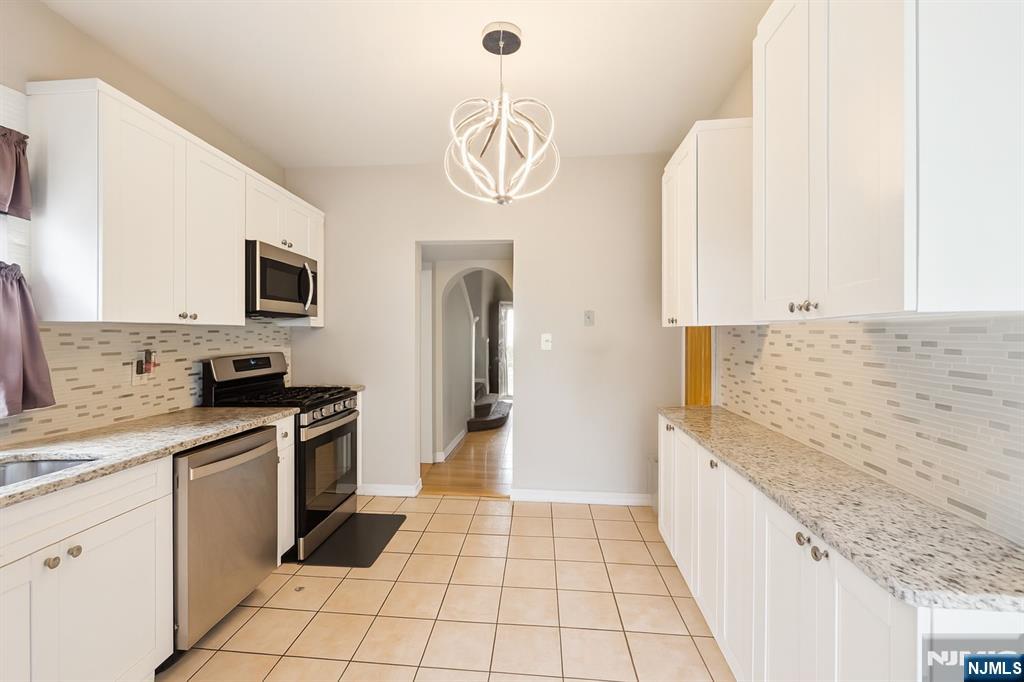 309 Lookout Avenue Hackensack, NJ 07601 - Photo 5 of 25 a kitchen with stainless steel appliances granite countertop a sink and a stove