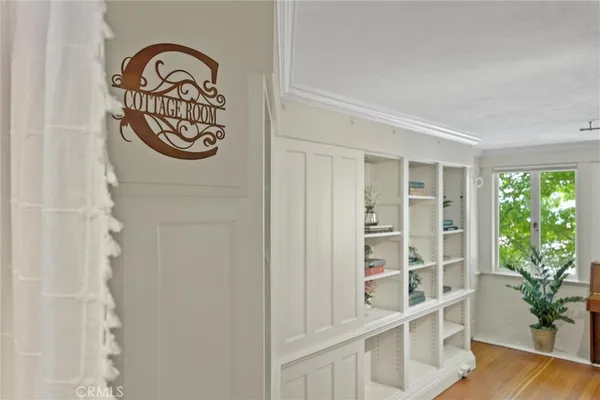 a view of empty room with wooden floor and windows