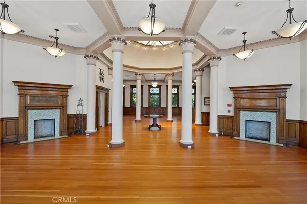 a living room with a fireplace windows and a wooden floor
