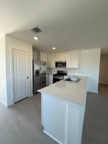 a kitchen with stainless steel appliances a refrigerator sink and cabinets