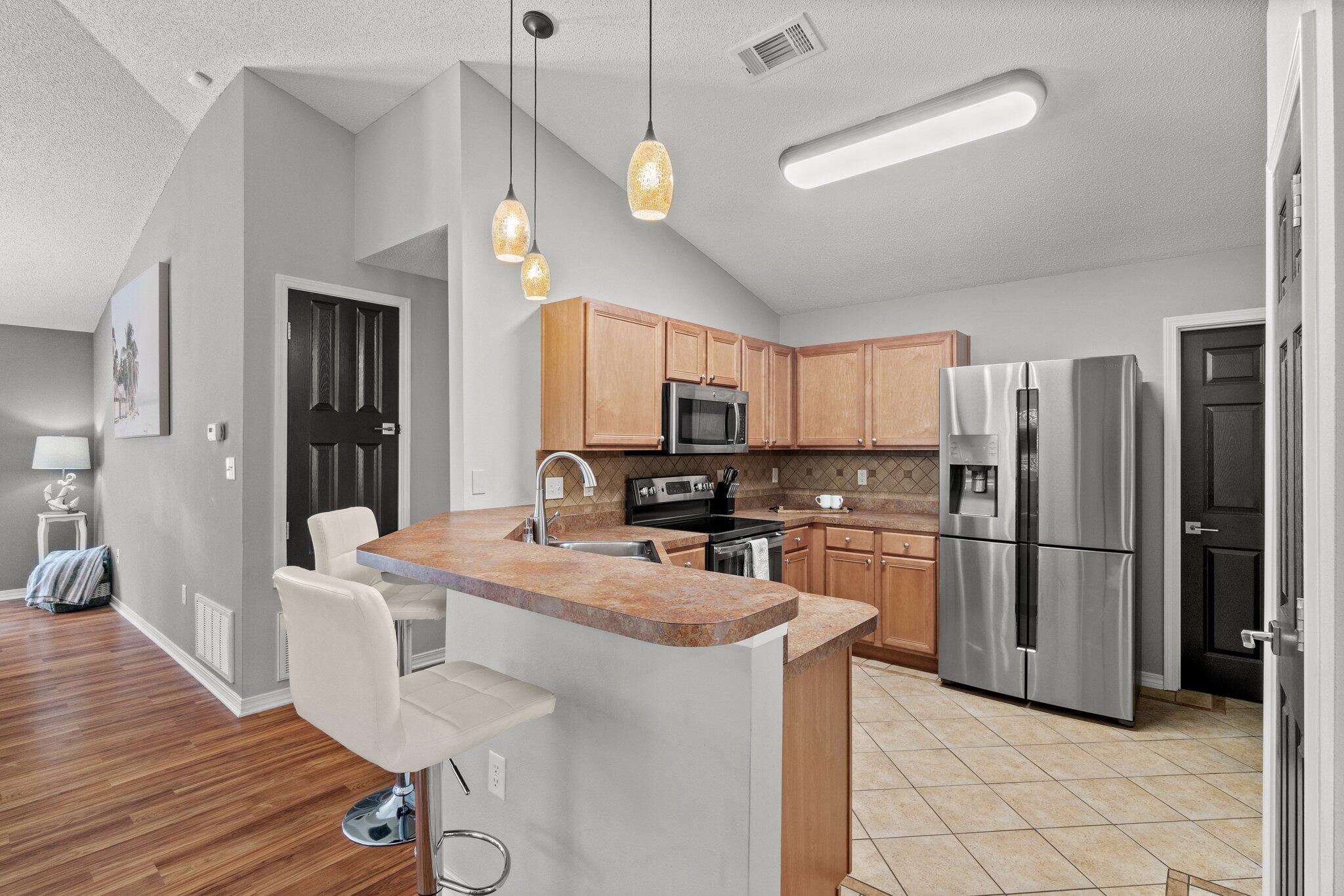 125 Bayou Landing Road Miramar Beach, FL 32550 - Photo 5 of 21 a kitchen with a refrigerator a stove top oven a sink dishwasher with a dining table and chairs