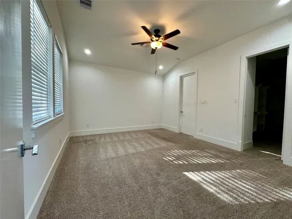 an empty room with windows and fan view