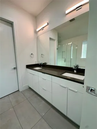 a spacious bathroom with a double vanity sink and a mirror