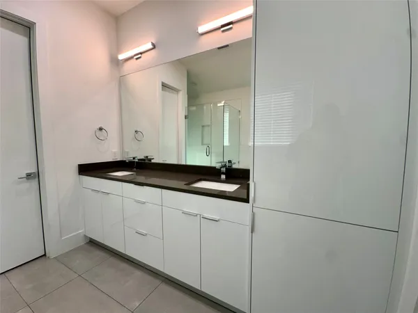 a bathroom with a double vanity sink and a mirror