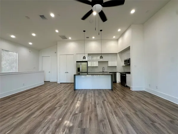 a large kitchen with stainless steel appliances granite countertop a large center island and a sink