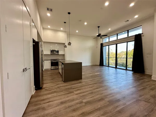 a view of kitchen with stainless steel appliances granite countertop a stove and a refrigerator