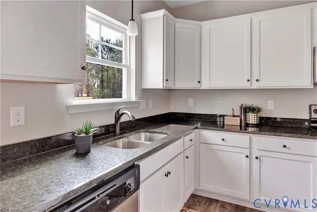 a kitchen with granite countertop white cabinets and white appliances