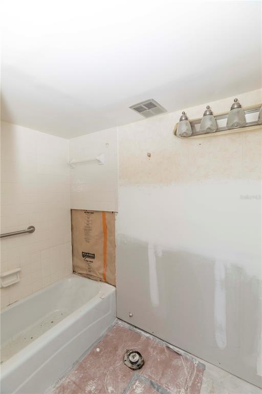 4715 Jasper Drive, Unit 107 New Port Richey, FL 34652 - Photo 14 of 22 a bathroom with a bathtub and a shower