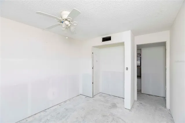 an empty room with a ceiling fan and a window