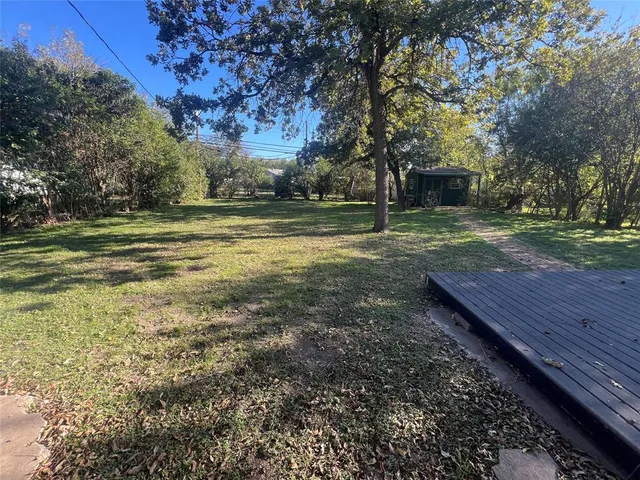 a view of a yard with wooden fence