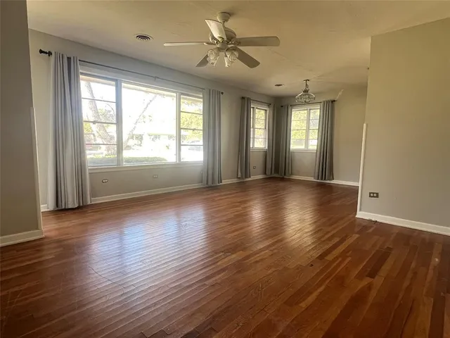 a view of n empty room with window and wooden floor