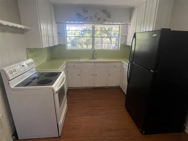a utility room with wooden floor washer and dryer