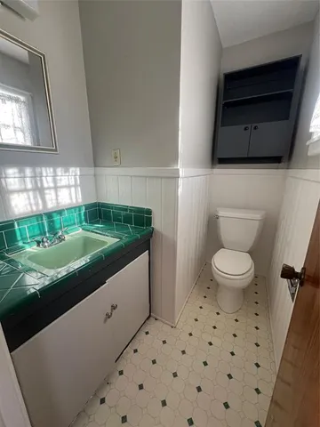 a bathroom with a toilet a sink and a mirror