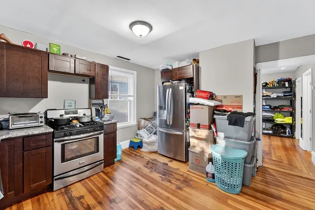 a kitchen with stainless steel appliances granite countertop a stove and wooden cabinets