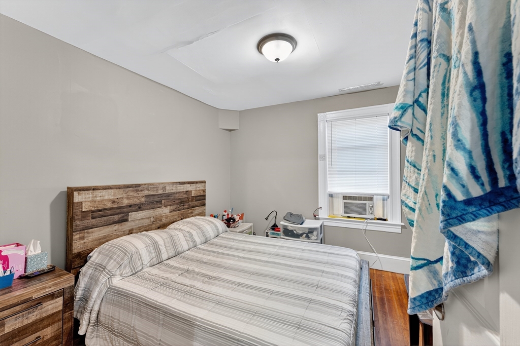 24-26 Pendleton Street Cranston, RI 02920 - Photo 12 of 25 a bed sitting in a bedroom next to a window