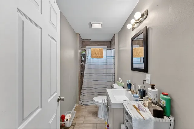 a bathroom with a sink mirror and a toilet