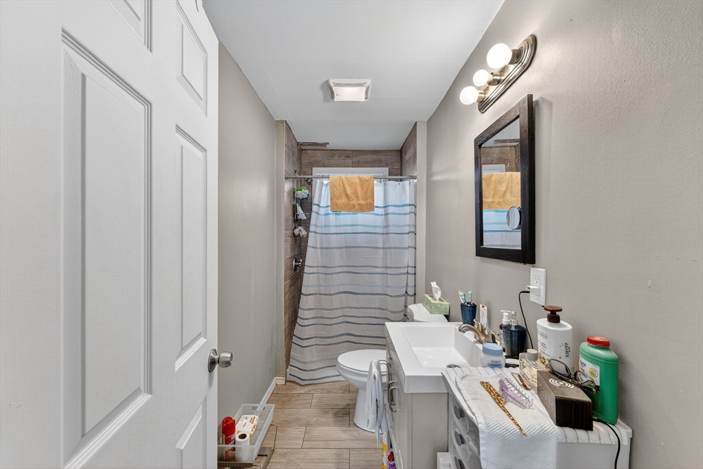 24-26 Pendleton Street Cranston, RI 02920 - Photo 13 of 25 a bathroom with a sink mirror and a toilet