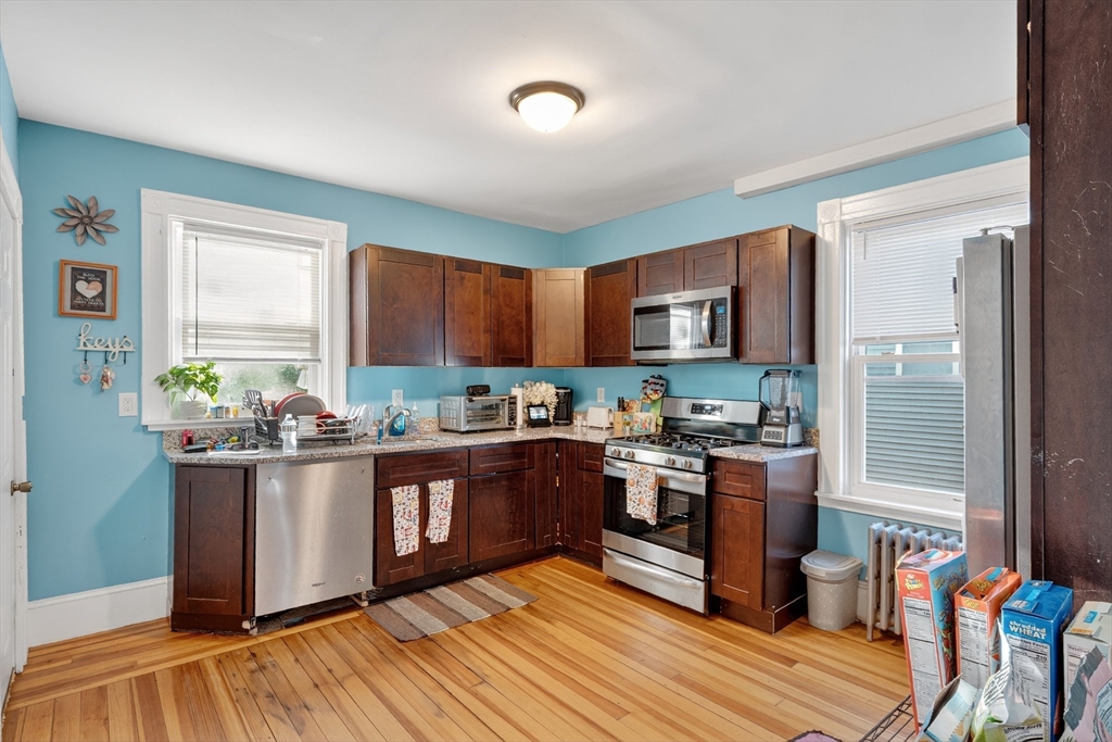 24-26 Pendleton Street Cranston, RI 02920 - Photo 4 of 25 a kitchen with stainless steel appliances granite countertop a stove and a refrigerator