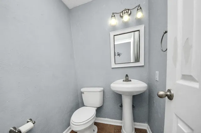 a bathroom with a granite countertop toilet and sink