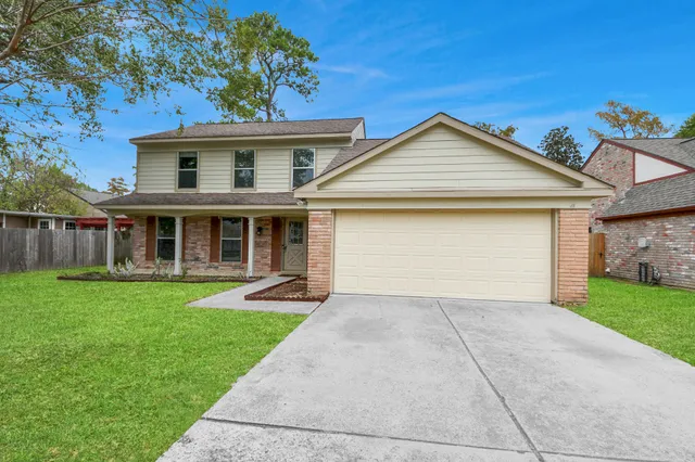 front view of a house with a yard and an trees
