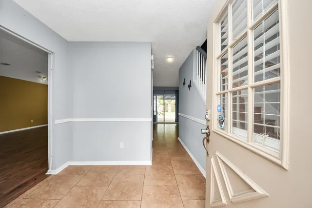 a view of a hallway with wooden floor and windows