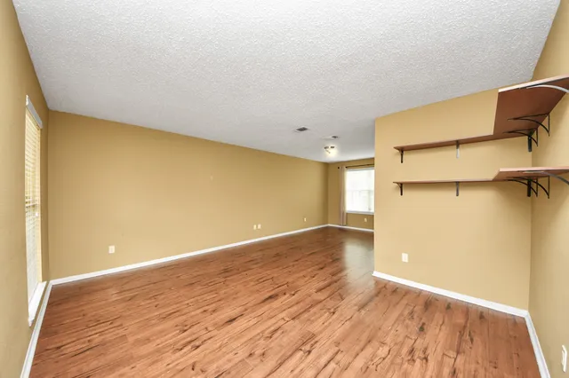 a view of a room with wooden floor and a hallway