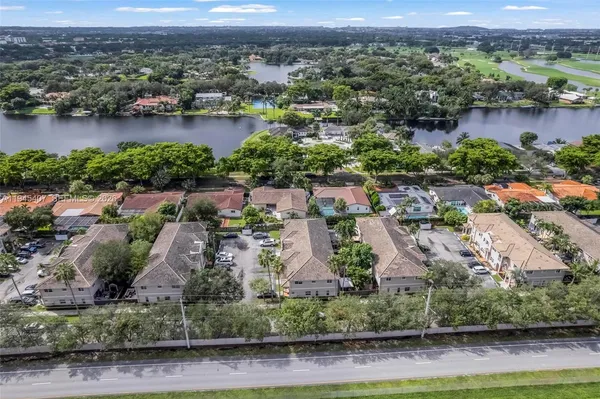 an aerial view of residential houses with outdoor space and lake view